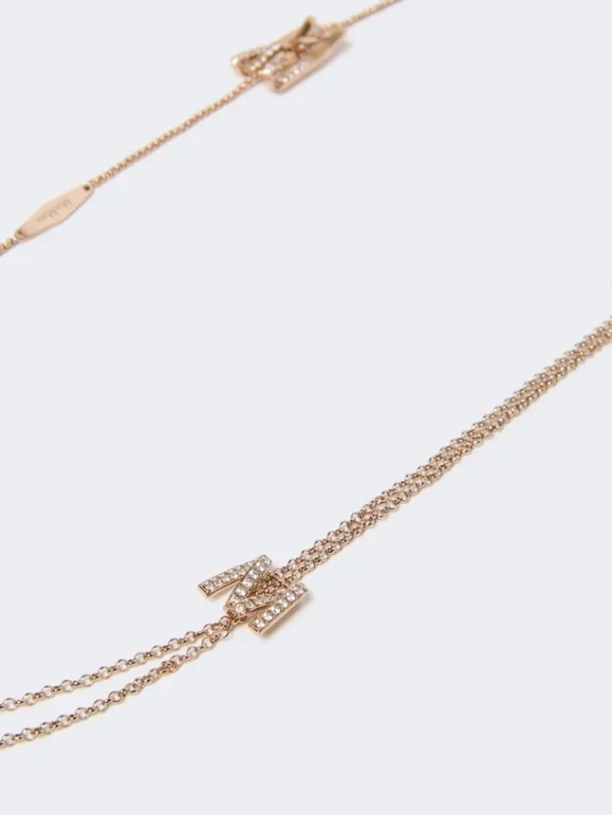 Långt halsband med monogramdetaljer, elfenben Långt halsband med monogramdetaljer, elfenben